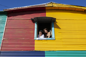Women at window, colorful house, La Boca, Buenos Aires, Argentina