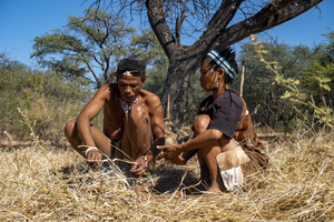 Bushman and woman in Kalahari making fire, San, Botswana