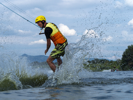 Mann bei Sprung mit Wakeboard, Wassersport, Wasserski und Wakepark, Stráž pod Ralskem, Tschechien