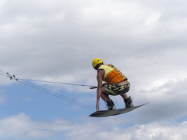 Sportlicher Mann bei Sprung mit Wakeboard, Wassersport, Wasserski und Wakepark, Stráž pod Ralskem, Tschechien