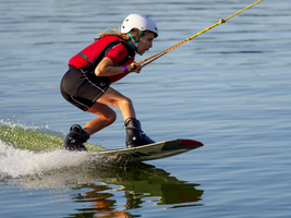 Junge oder Mädchen mit Wakeboard im See, rote Weste, Wassersport, Wasserski im Wakepark, Stráž pod Ralskem, Tschechien