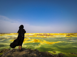 Woman with burqa, geothermal area with sulfur deposits and acidic salt paints, Dallol, Danakil Depression, Ethiopia, Africa