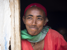 Laughing woman mud hut
