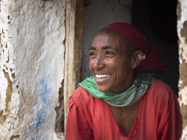 Laughing woman in front of mud hut, portrait, Ethiopia, Africa