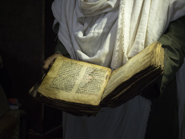 Priest holds holy old book, Ethiopia, Africa