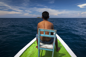 Man at bow on small boat, Flores, Indonesia