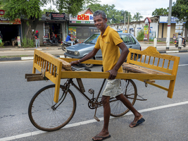 Mann mit Bettgestell auf altem Fahrrad, Sri Lanka