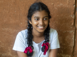 Singhalesisches Schulmädchen mit weißer Kleidung, schwarzen Zöpfen und roten Schleifen, Sri Lanka