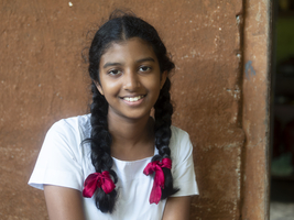 Singhalesisches Schulmädchen mit weißer Kleidung, schwarzen Zöpfen und roten Schleifen, Sri Lanka