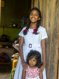 Singhalesisches Schulmädchen mit weißer Kleidung, schwarzen Zöpfen und roten Schleifen, Sri Lanka