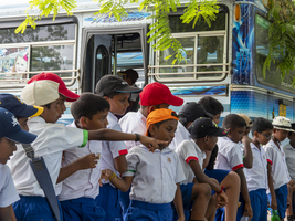 Schulkinder mit Schulbus und Schuluniform bei einem Ausflug, Sri Lanka