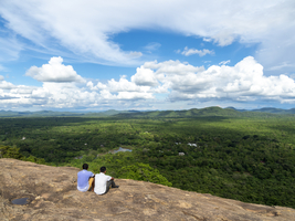 Männer sitzen auf Felsen, Blick in die Landschaft, Pidurangala, Sri Lanka