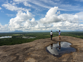 Männer stehen auf Felsen, Spiegelbild in Pfütze, Blick in die Landschaft, Pidurangala, Sri Lanka