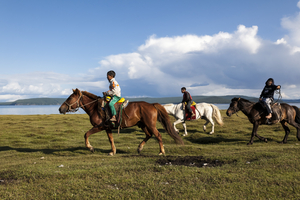 Mongolische Jungen zu Pferde in der Steppe, Mongolei
