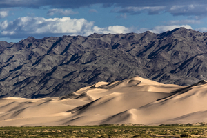 Hongor sand dune in front of mountain range, Gobi desert, Mongolia
