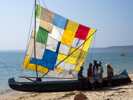 Boat with colored sails and people on the beach, Sarondrano, Madagascar