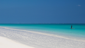 White beach and little fishing boat in turquoise sea, Ambatomilo, Madagascar