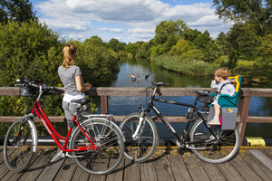 Excursion with bicycles, stop at bridge, view of Spree river, Spreewald, Germany