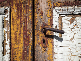 Old dilapidated door with handle and with old paint, Germany