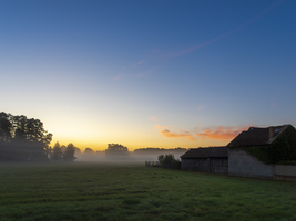 Morgennebel über den weiten Wiesen und Auen, bunter Himmel, ein altes Bauernhaus, Schlepzig, Spreewald, Brandenburg, Deutschland