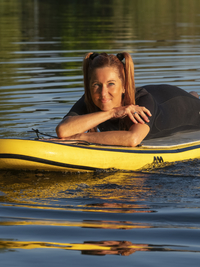 Frau liegt auf standup paddle board im See, Deutschland