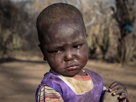 Little African girl, sad, Bushmen village, Tanzania
