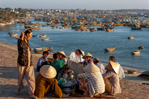Frauen sitzen vor Fischereihafen mit vielen Booten, Mui Nee, Vietnam