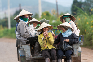 Lachende vietnamesische Frauen mit Reishut auf Traktor, Vietnam