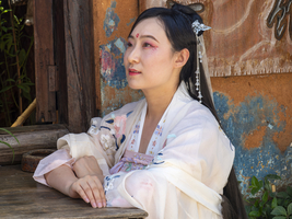 Frau in chinesischer Nostalgie mit altem luxuriösen weißen Kleid vor altem Haus, historische Altstadt Dali, Yunnan, Chin