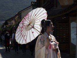 Frau in chinesischer Nostalgie, Sonnenschirm und altes luxuriöses Kleid, historische Altstadt Dali, Yunnan, China