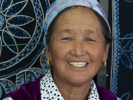 Verkäuferin in ihrem Laden für Kleider und Tücher, Xizhou, Yunnan, China