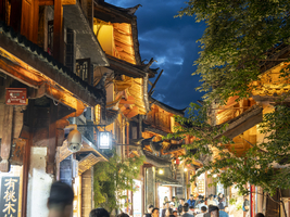 Alte beleuchtete chinesische Holzhäuser, viele Menschen in den Gassen, historischen Altstadt von Lijiang, Yunnan, China