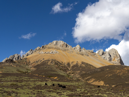 Bergketten, Schneefelder und Wiesen im Hochland von Ost-Tibet, China