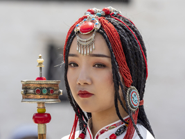 Tibetische junge Frau mit festlichem Haarschmuck, Halsketten und Gebetsmühle, exotische Prinzessin, Lhasa, Tibet, China