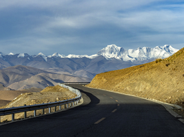 Straße mit Blick auf Gebirgskette der Achttausender Gipfel, Tibet, China