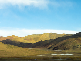 Berglandschaft und Ebene mit Flussbett  im Hochland von Tibet, China