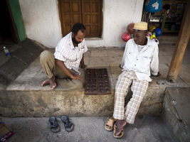 Men play bao (mancala game), players in a street of Stonetown, Zanzibar, 2017