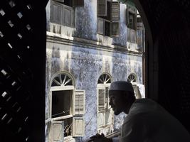 Arab man at the window, old alley, Stone Town, Zanzibar