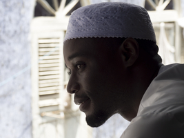 Arab man at the window, old alley, Stone Town, Zanzibar