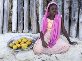 Girl sells mangoes, beach, Zanzibar